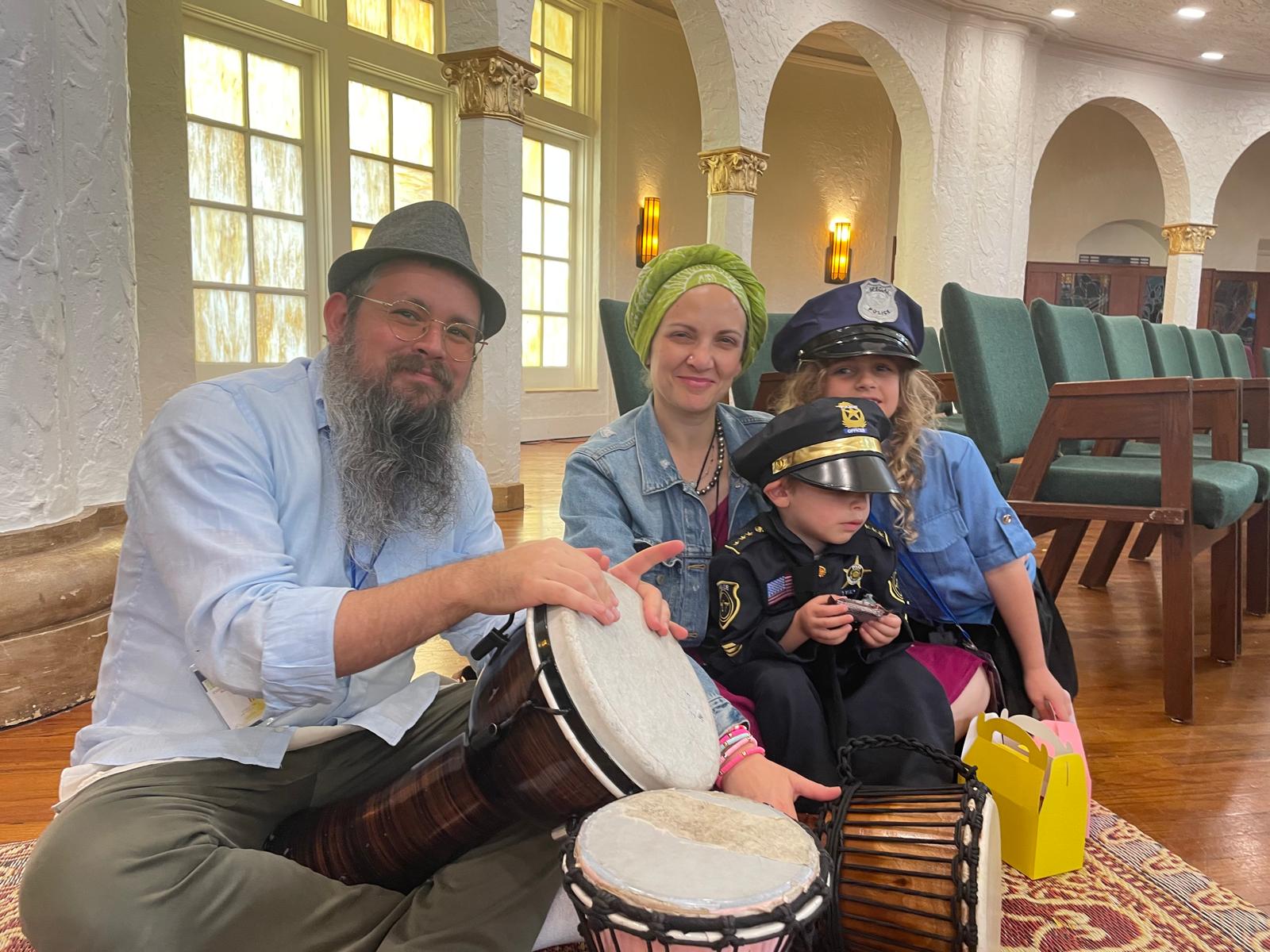 Family drumming together at a community event